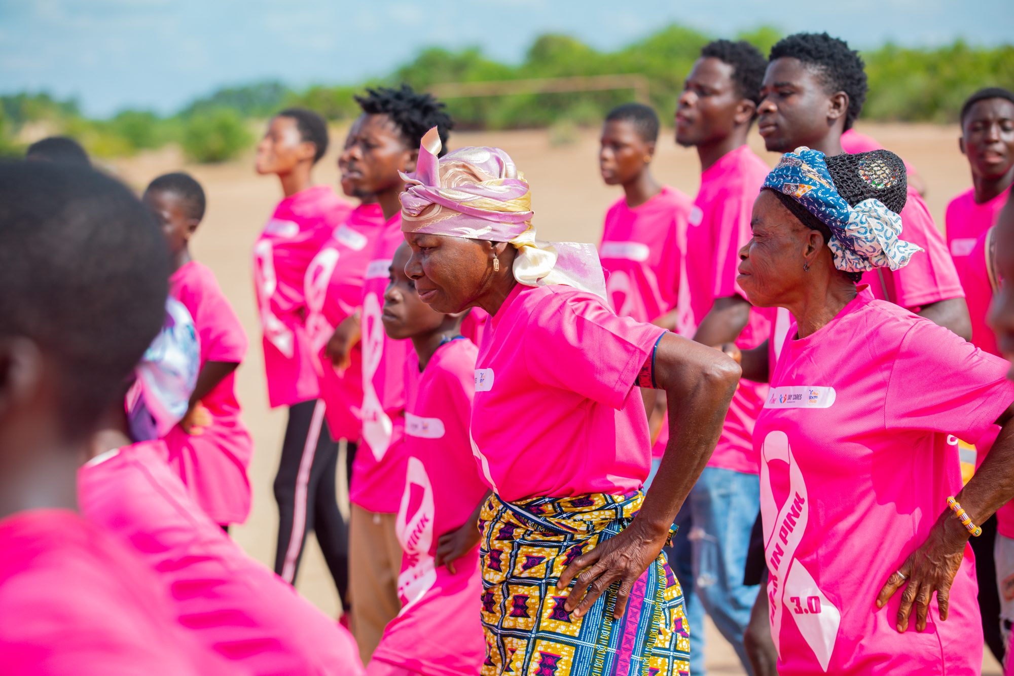 Women in Walk In Pink shirts dancing together at the 2024 walk